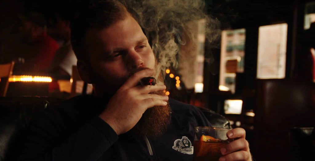 Man smoke while drinking alcohol