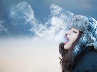 Woman with dark blue jacket with smoke